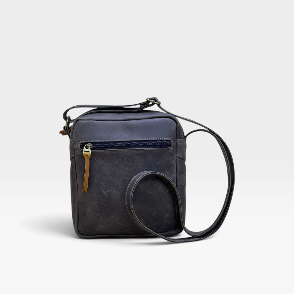 Bolso manos libres kopelletteria en cuero rústico azul profundo con cremallera y correa ajustable para hombre.