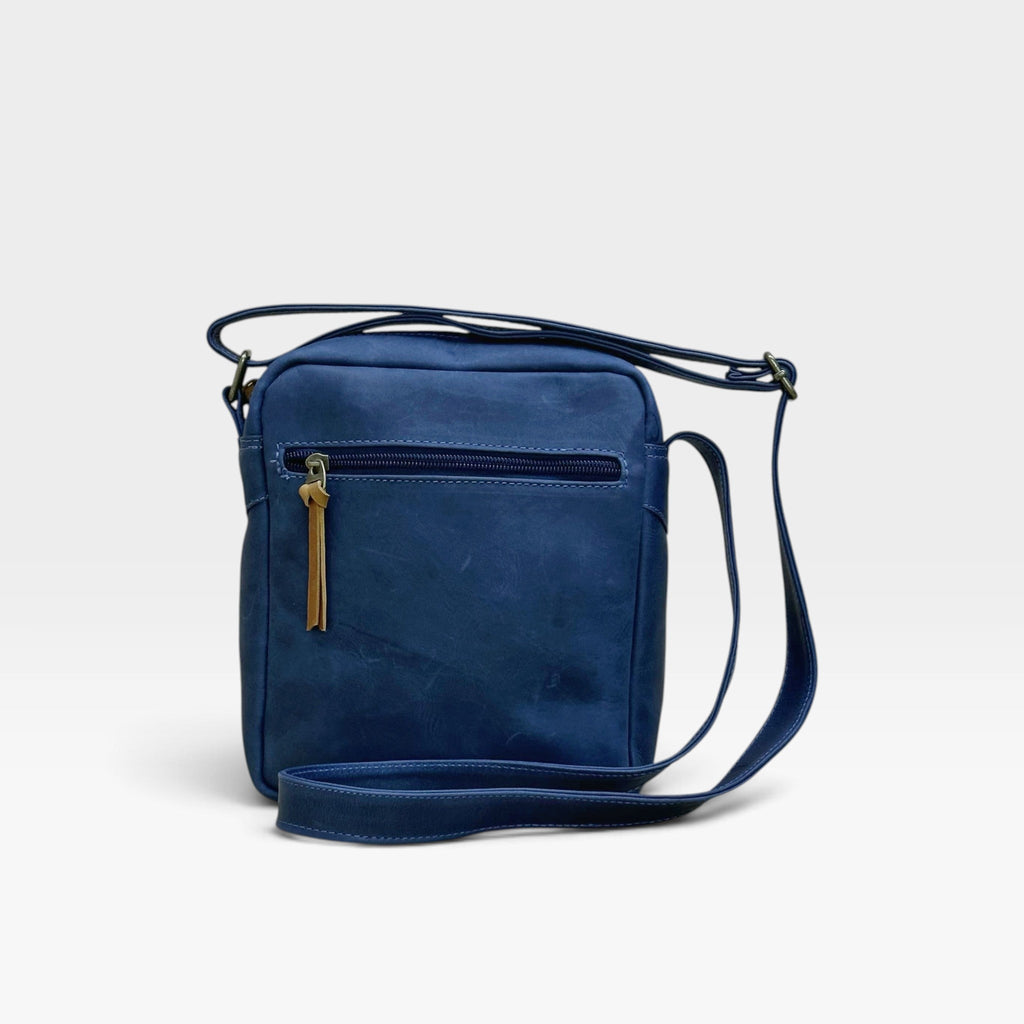 Bolso manos libres kopelletteria en cuero rústico azul profundo con correa ajustable y cremallera de acento miel.