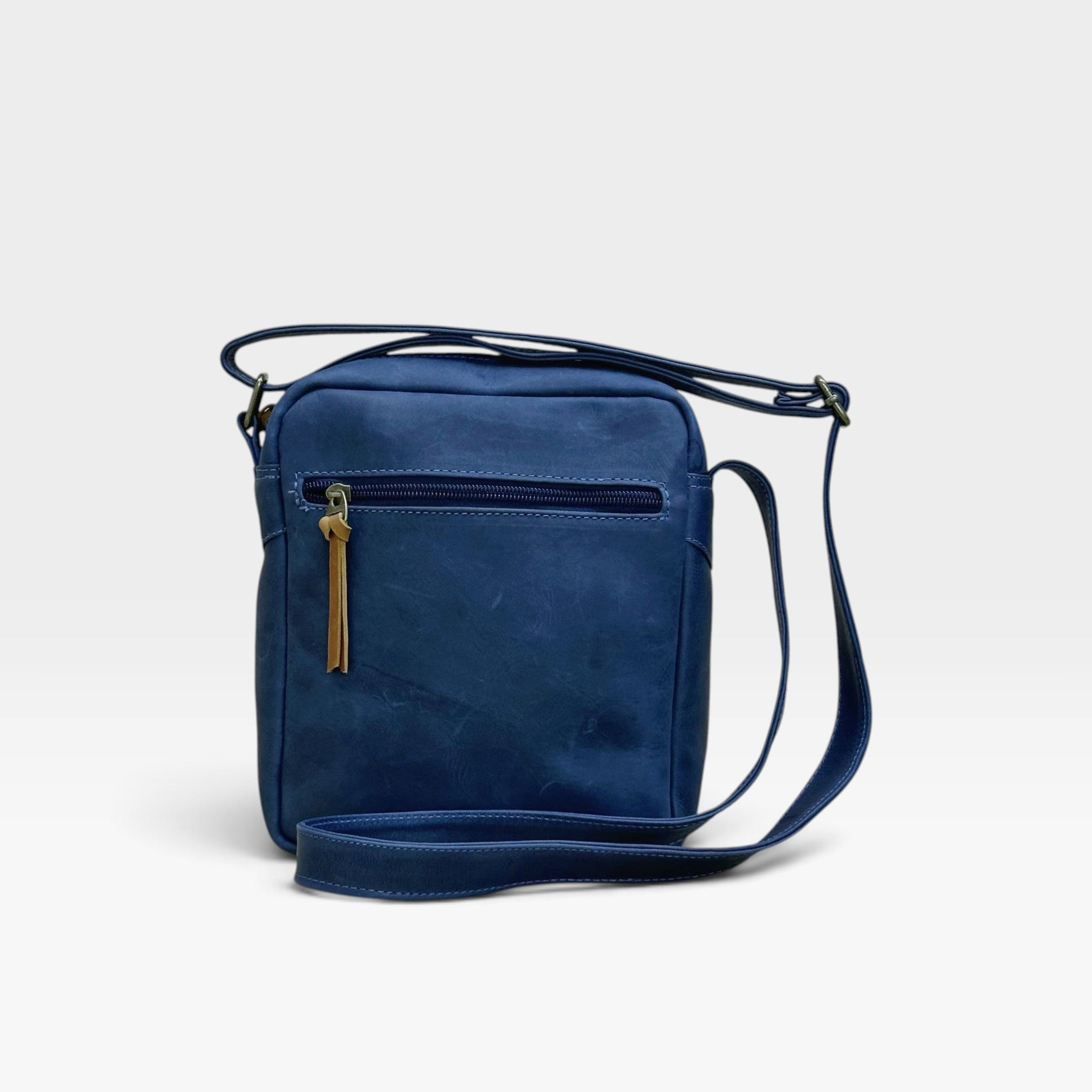 Bolso manos libres kopelletteria en cuero rústico azul profundo con correa ajustable y cremallera de acento miel.