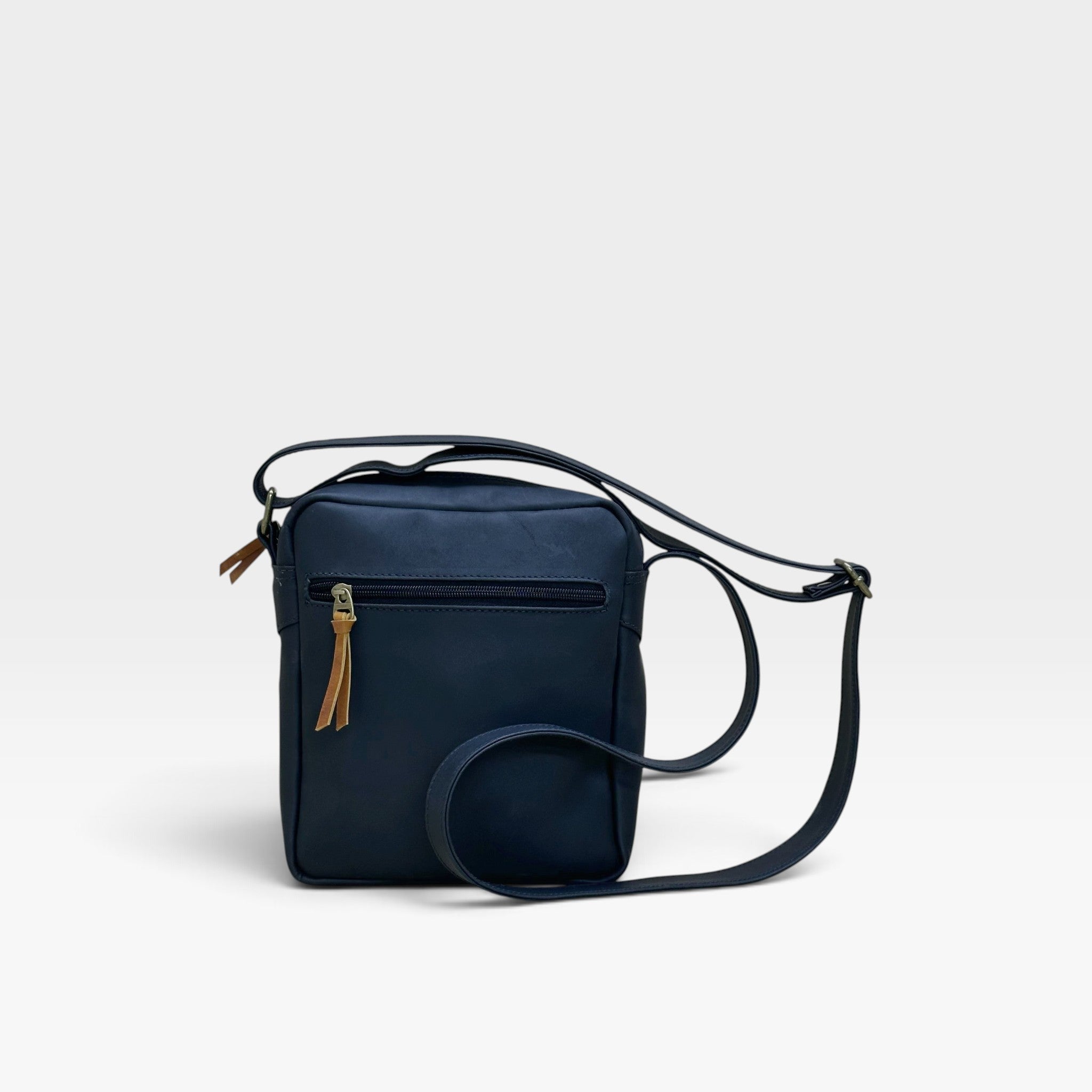 Bolso manos libres kopelletteria en cuero azul profundo con detalles en color miel y correa ajustable para hombre