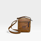 Bolso manos libres kopelletteria en cuero rústico marrón ocre con detalles en azul, diseño minimalista y correa ajustable.