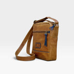 Bolso manos libres kopelletteria de cuero rústico marrón ocre con detalles en azul y correa ajustable para hombre.