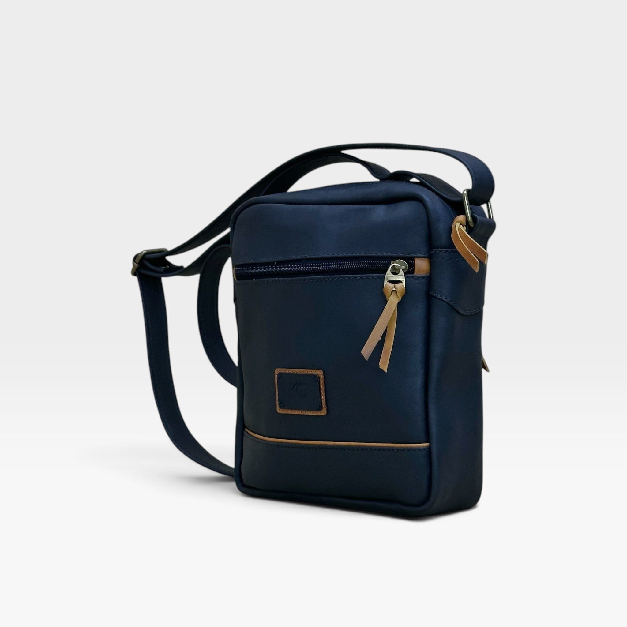 Bolso manos libres kopelletteria azul profundo en cuero genuino rústico con detalles en color miel y correa ajustable.