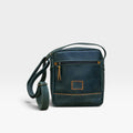 Bolso manos libres kopelletteria en cuero rústico azul profundo con detalles en color miel y correa ajustable.