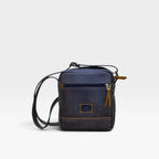 Bolso manos libres kopelletteria en cuero azul profundo con acentos miel, diseño minimalista y tres compartimentos.