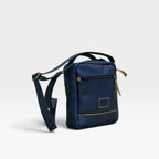 Bolso manos libres kopelletteria azul en cuero genuino con correa ajustable y compartimentos organizadores.