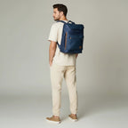 Hombre con morral azul de cuero genuino kopelletteria, diseño urbano con compartimento para laptop y detalles en cuero.